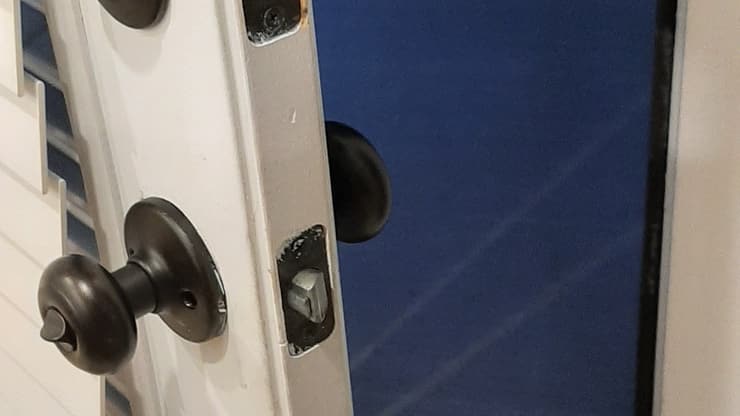 Close-up of new lock and knob hardware installed on a door