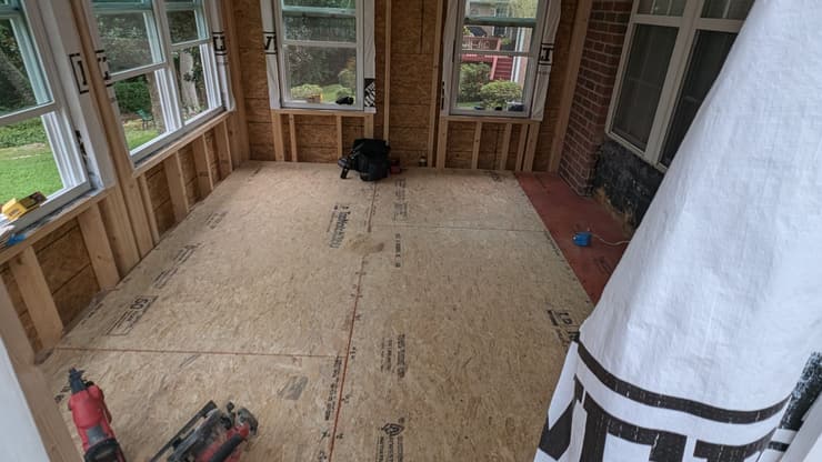 Sunroom under construction with wood framing and new windows