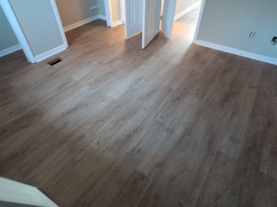 Newly installed grey wood-look plank flooring in an open room
