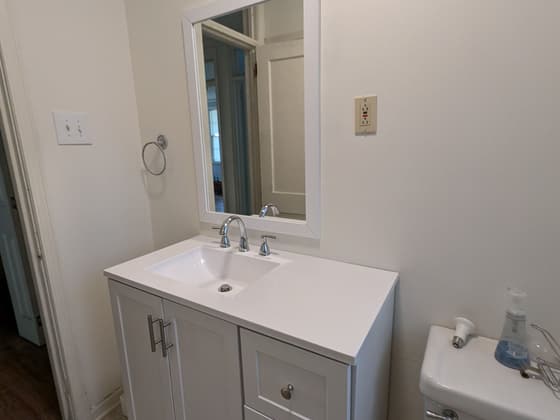 Bathroom with a white vanity, framed mirror and toilet