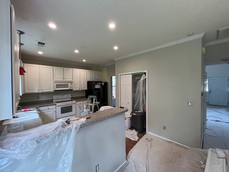 Kitchen after painting with white cabinets and the counters still protected