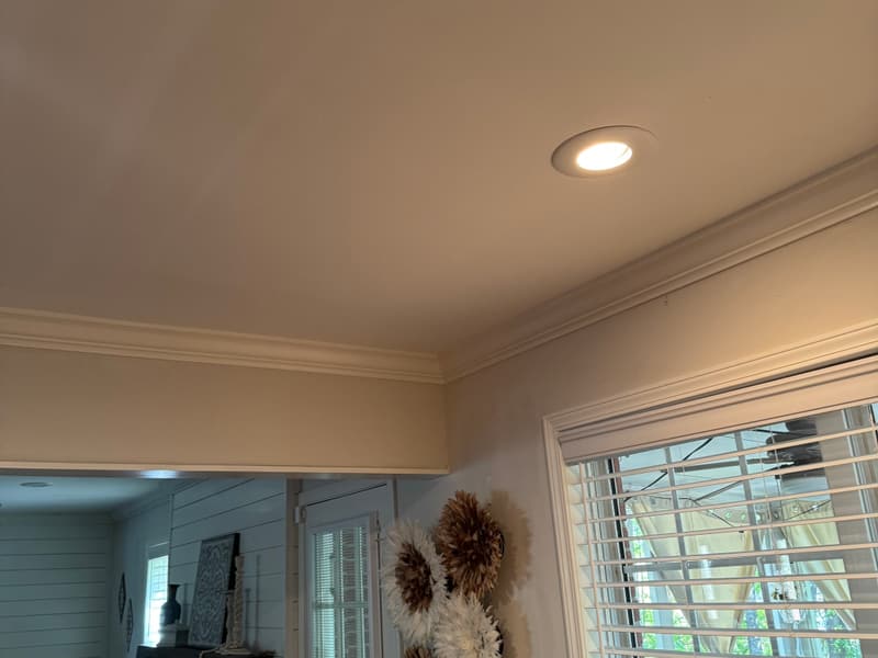 Freshly painted room corner with new crown molding, a recessed light and a window with blinds