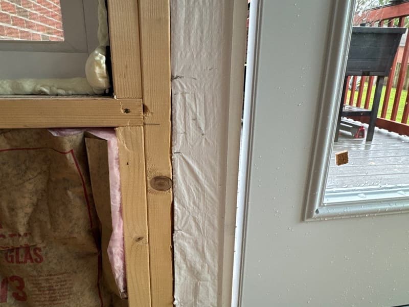 Interior of a room addition under construction with insulation in the walls and a new window