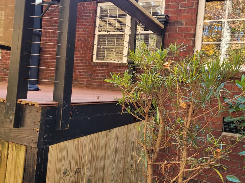 Rear of a brick house with new pressure-treated framing and deck work in progress